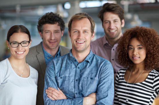 A diverse group of creative professionals looking positively at the camera.